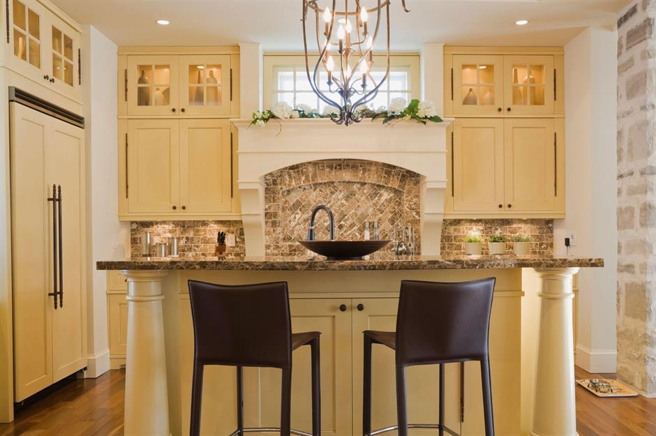 A small kitchen with stainless steel appliances, white cabinets, and a  natural light colored wood counter top Stock Photo - Alamy