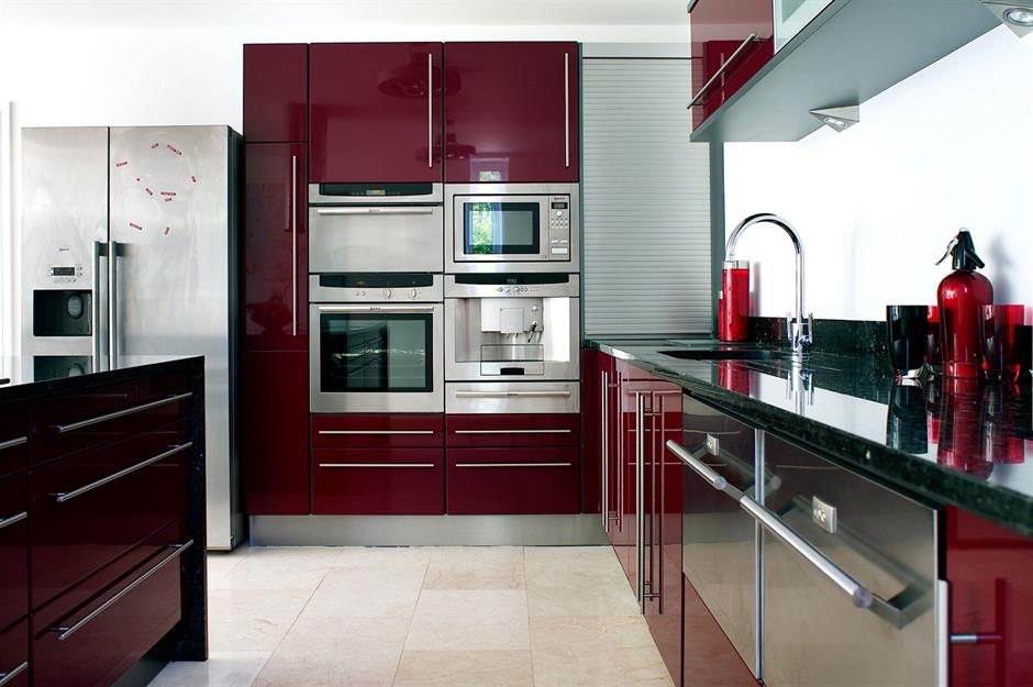 A small kitchen with stainless steel appliances, white cabinets, and a  natural light colored wood counter top Stock Photo - Alamy