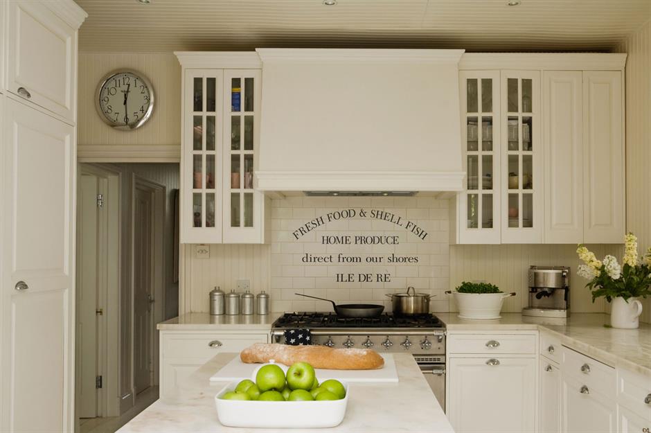 Kitchen with white stone countertops, solid wood cabinets, and vintage tile  on the walls Stock Photo - Alamy