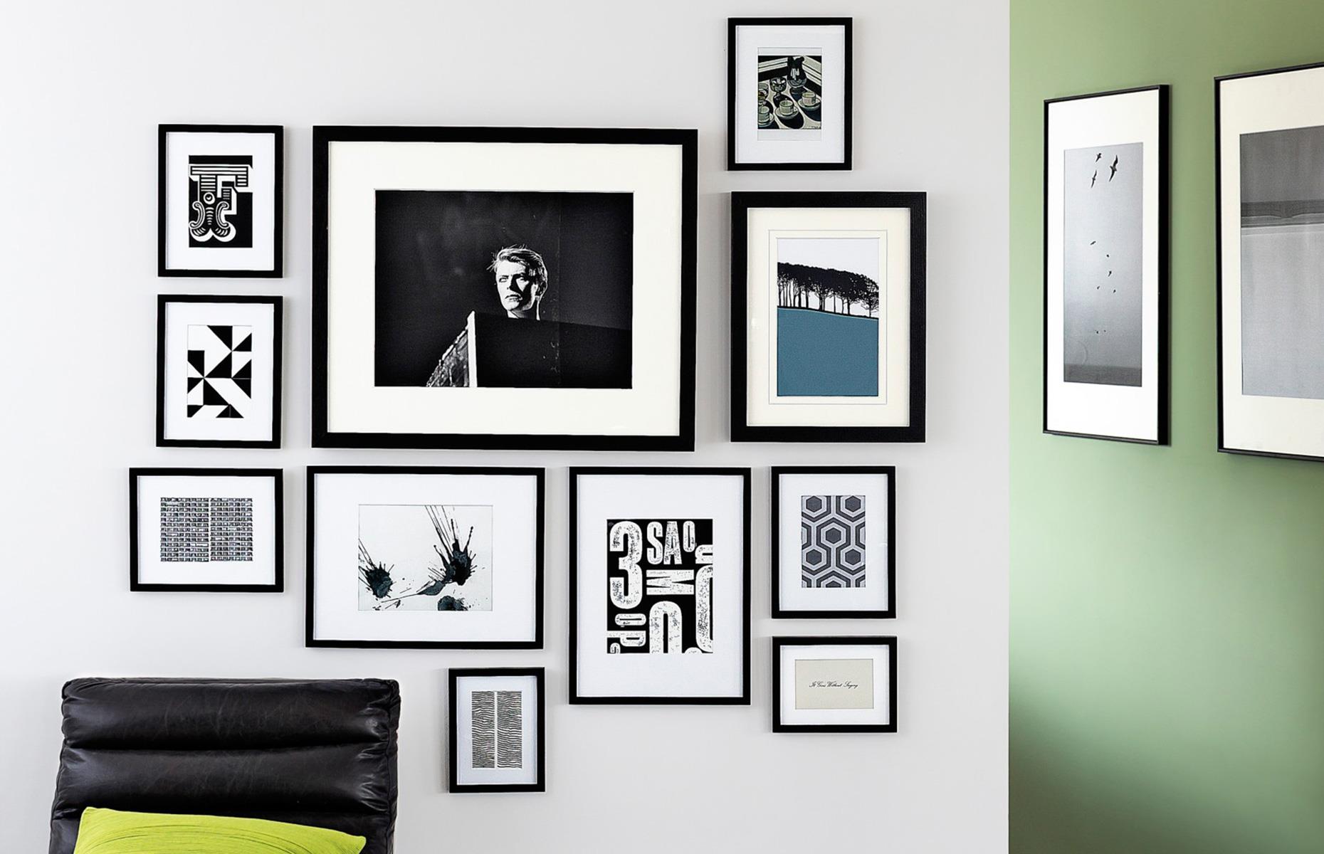 A gallery wall with photographs and graphic prints