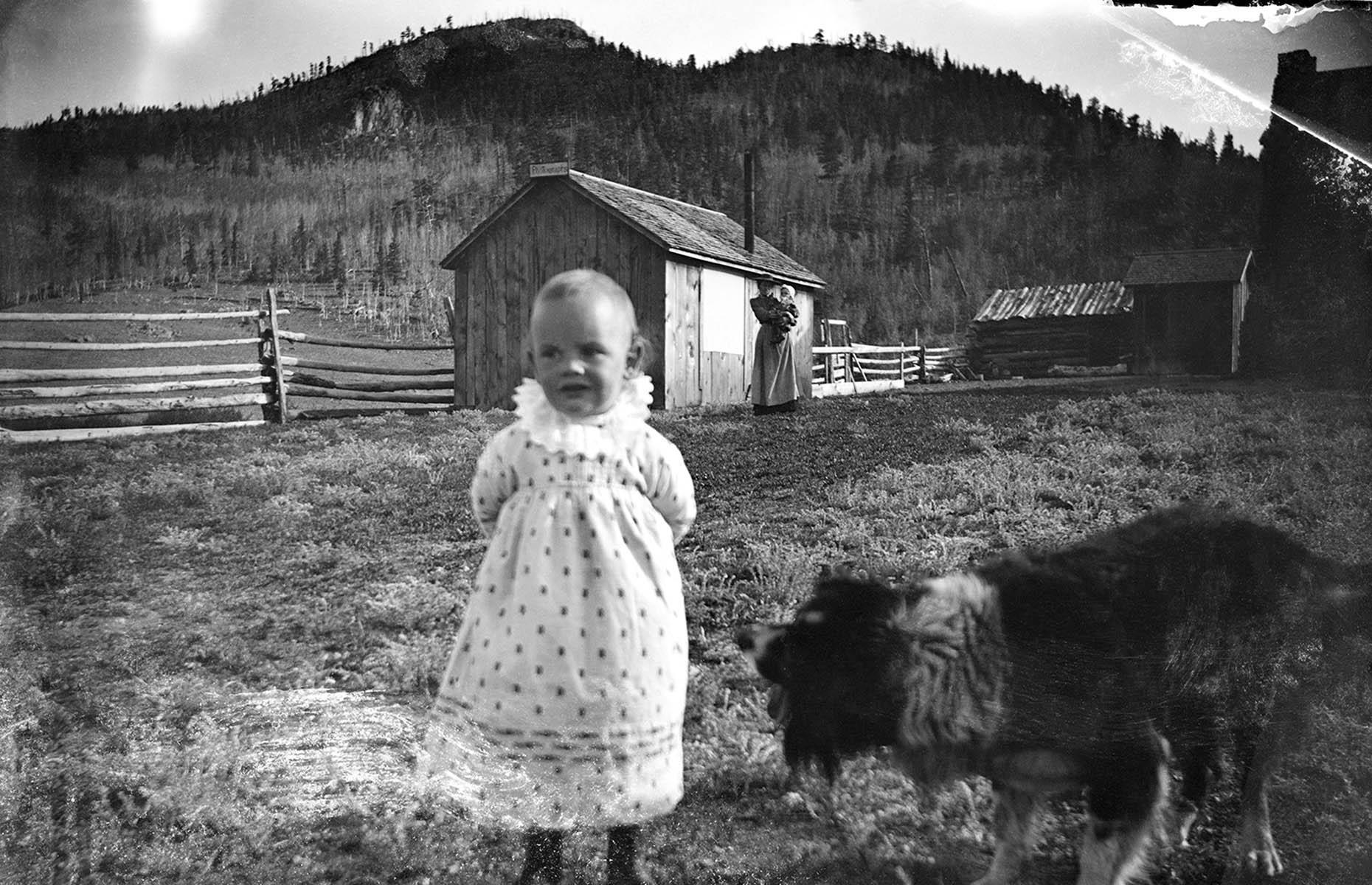 Un niño y un perro en la granja de Allen Ranch, Colorado, 1895