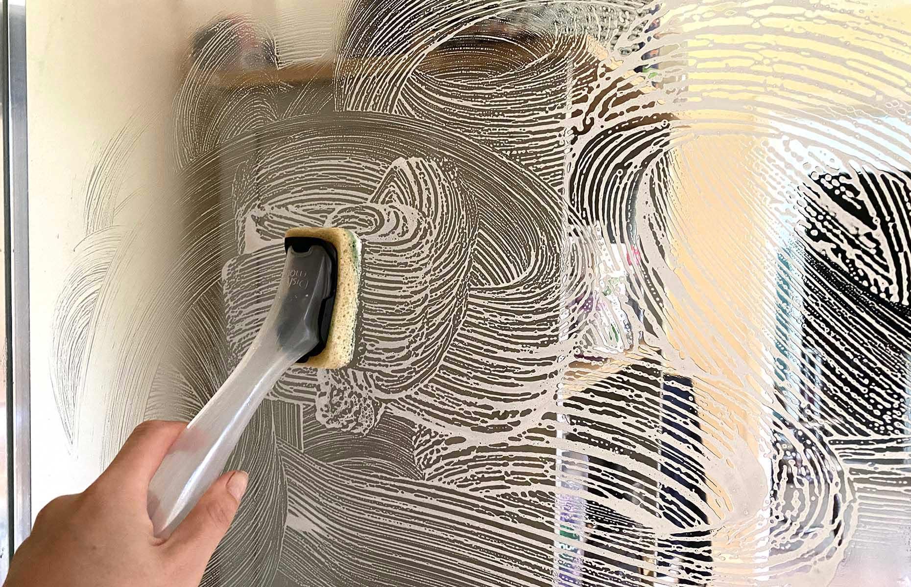 Limpia las puertas de la ducha con una esponjilla para platos 