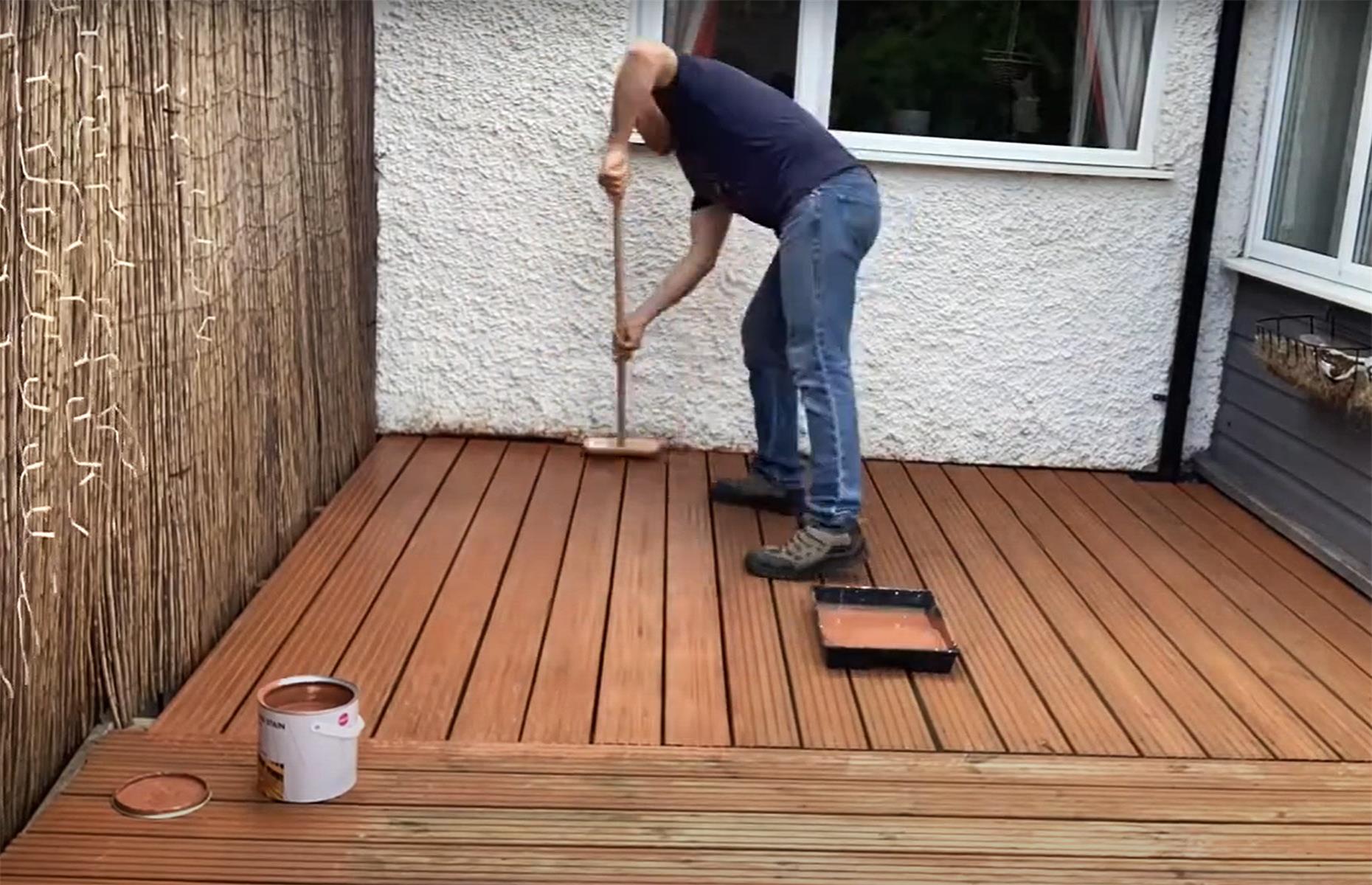 Paint decking with a broom