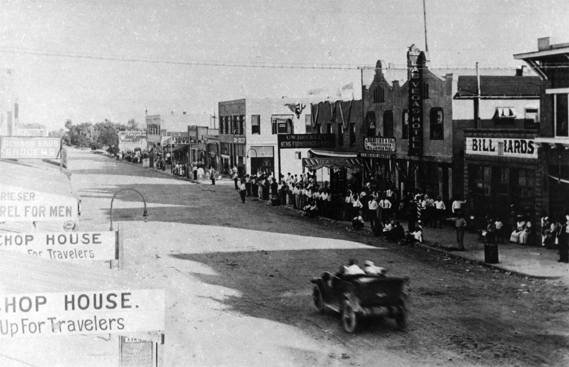 c.1928: a car drives down a busy Vegas street