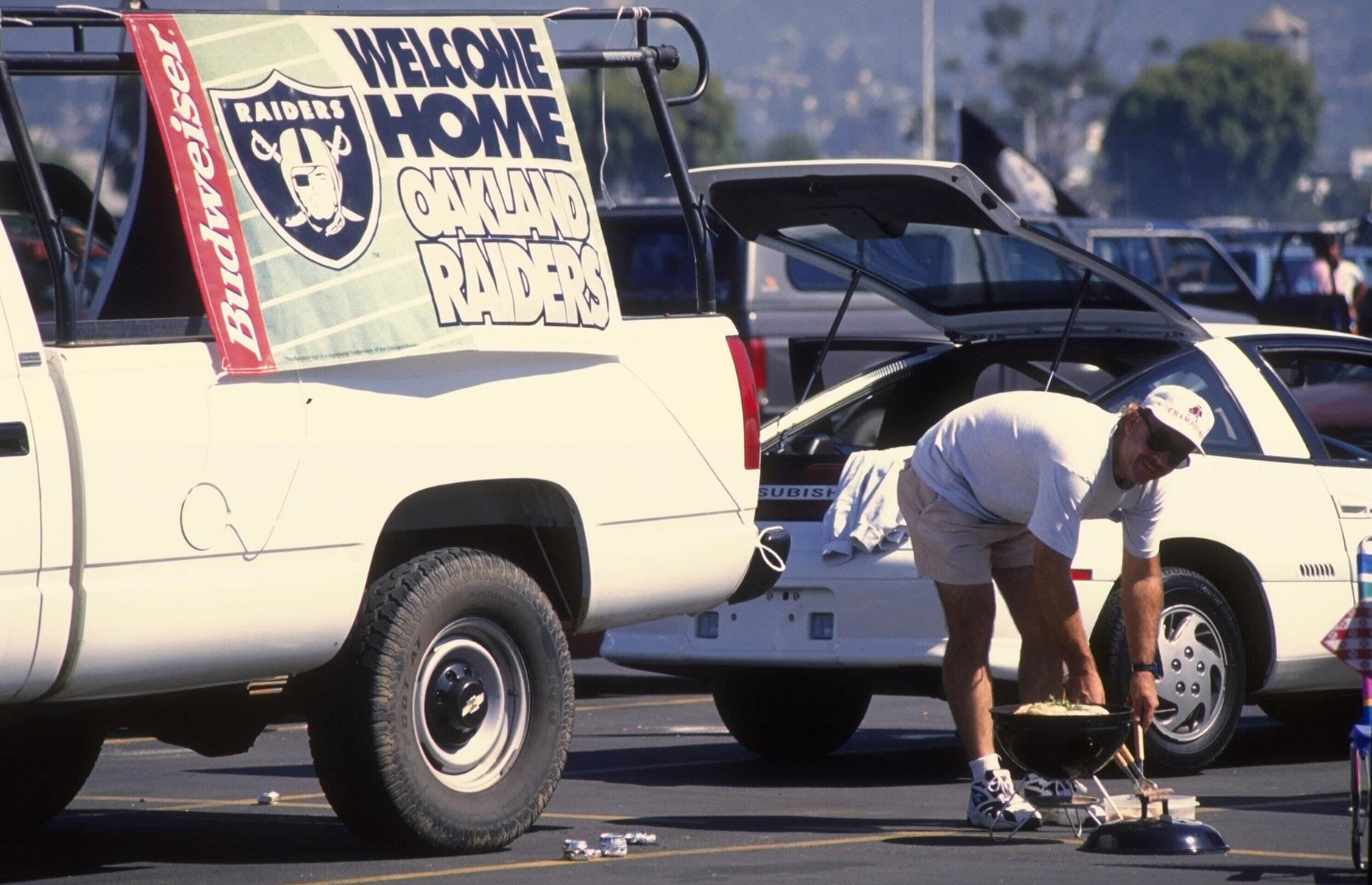 1990: a Raiders fan barbecues before a game