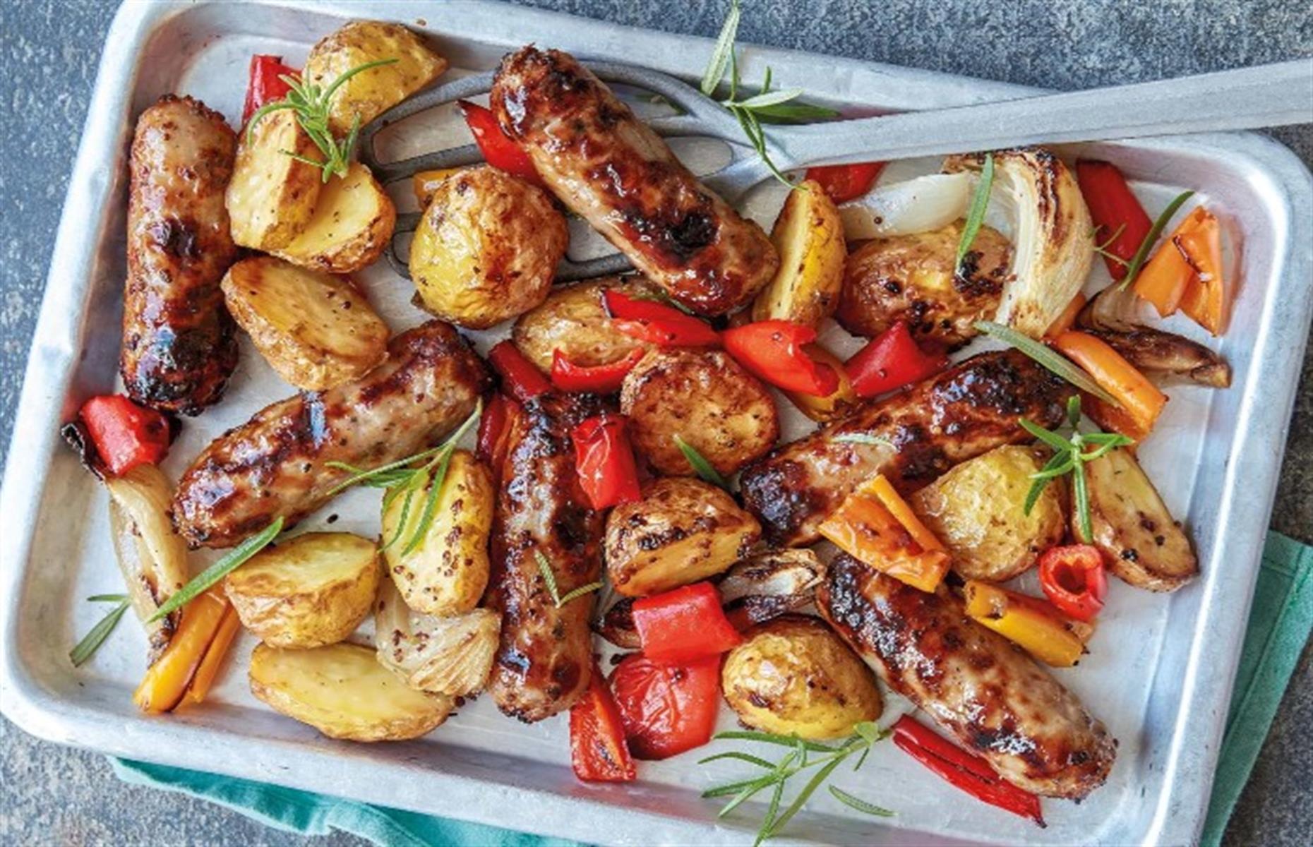 Honey and mustard sausages with potatoes, peppers and onions