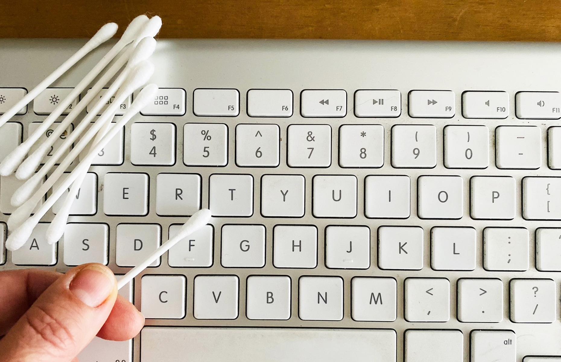 Limpiar un teclado sucio con copitos de algodón 