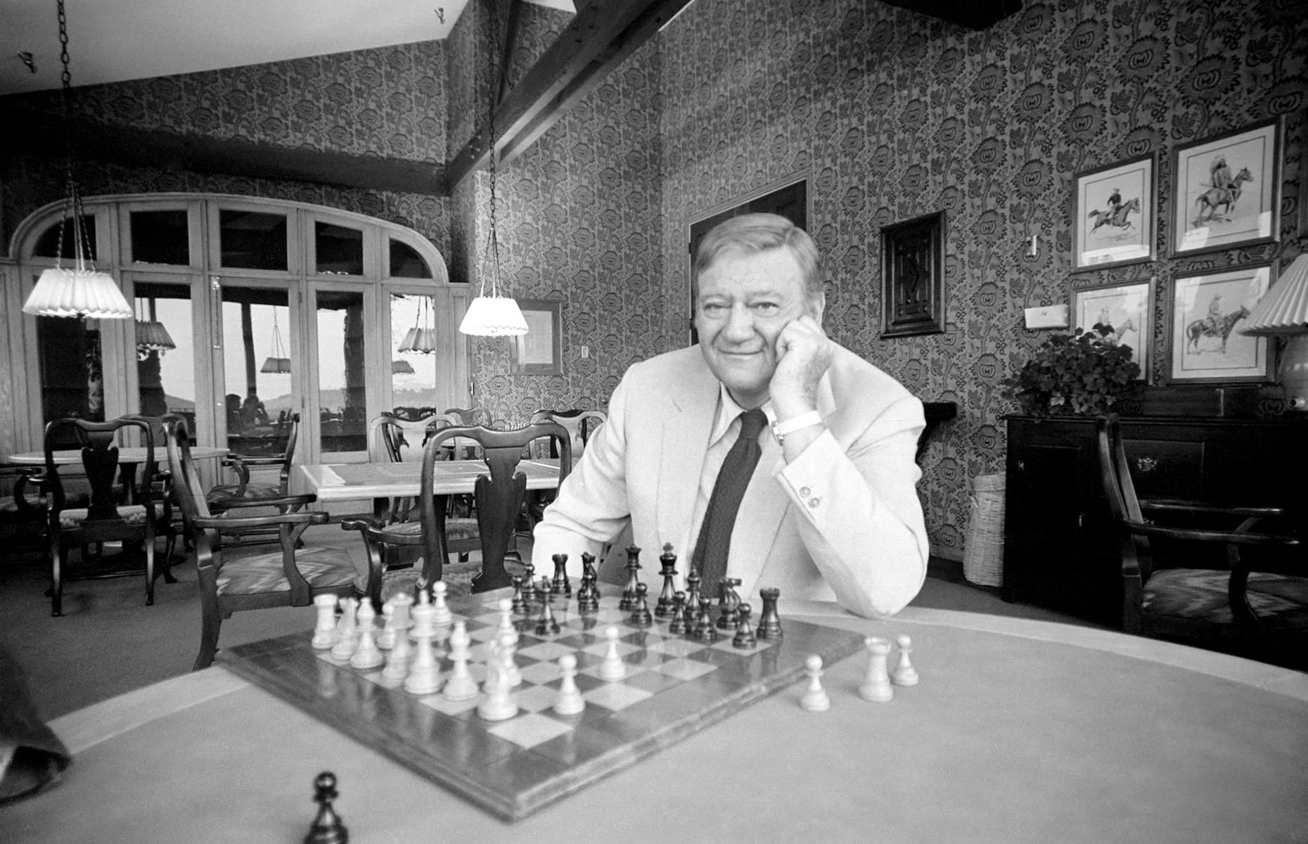 John Wayne playing chess at home