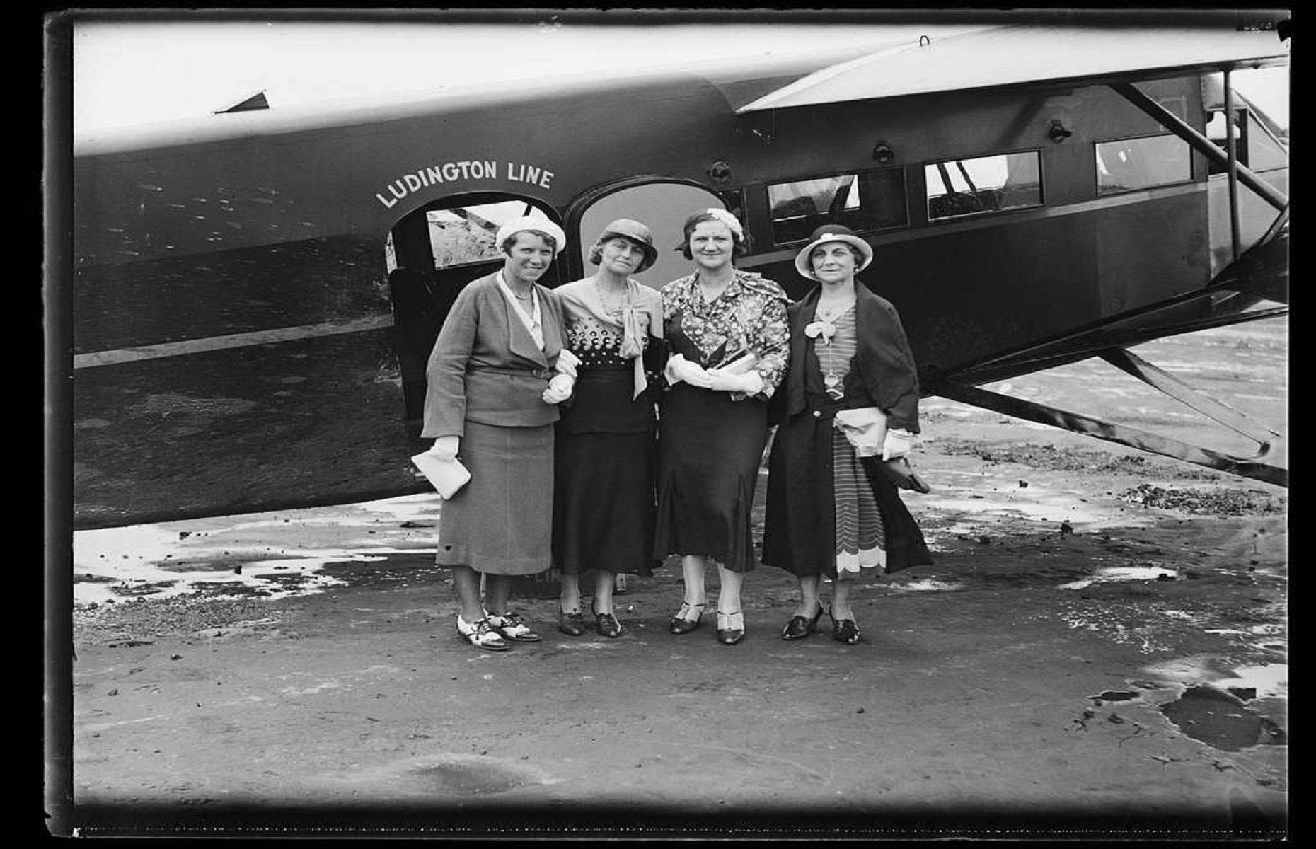 1930s: women in their finest attire wait to board a plane