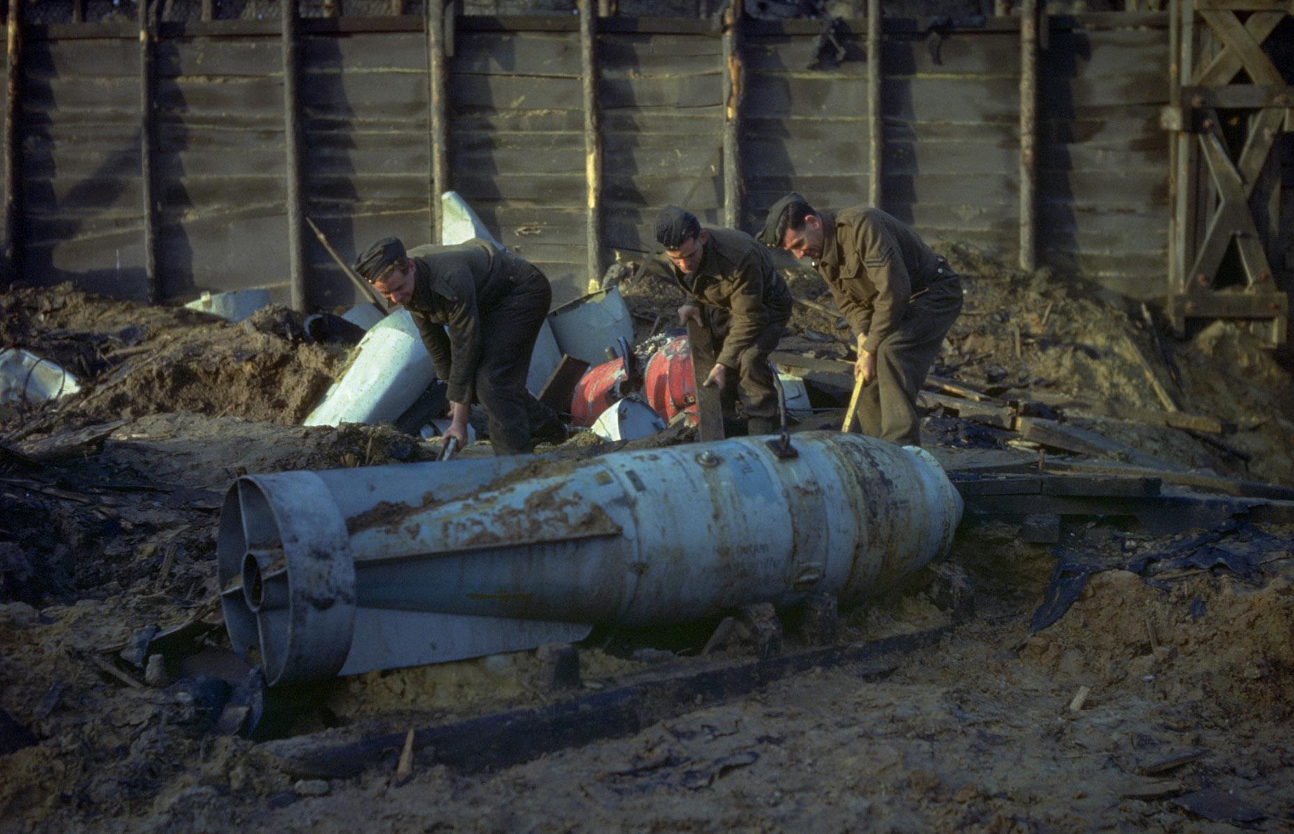 c 1940: soldiers attempt to free an unexploded bomb from sand, England