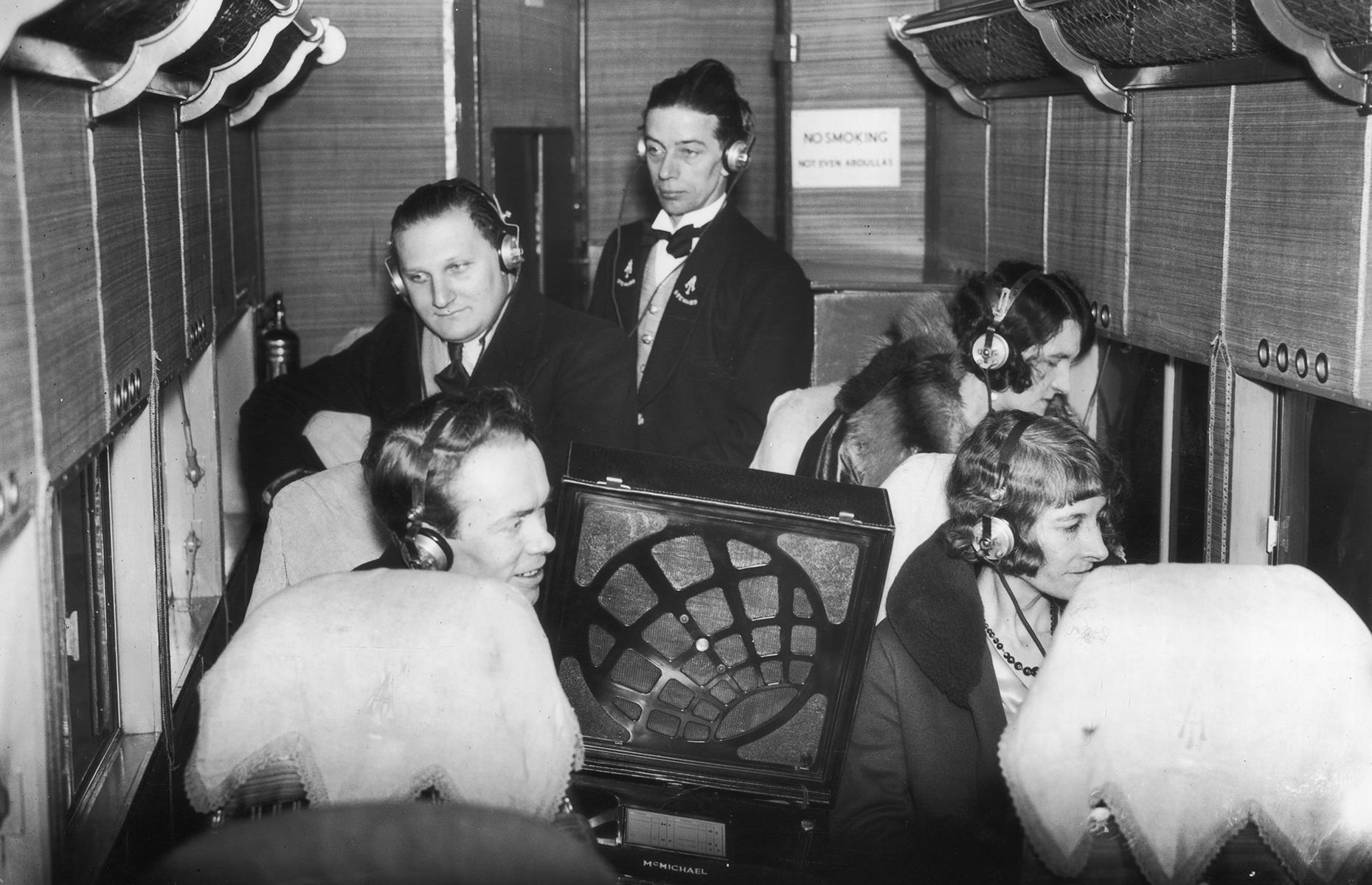 1930s: passengers listen to a broadcast aboard a flight