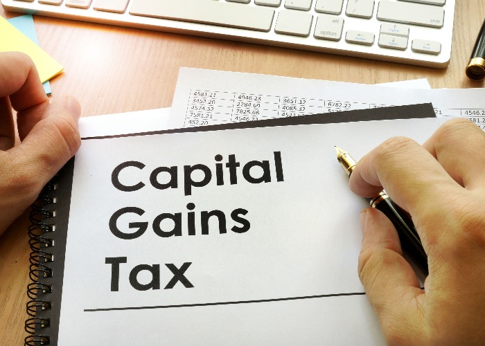 defer capital gains tax uk