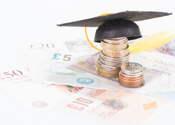 Notes and coins with a tiny mortarboard on top. (Image: Shutterstock)